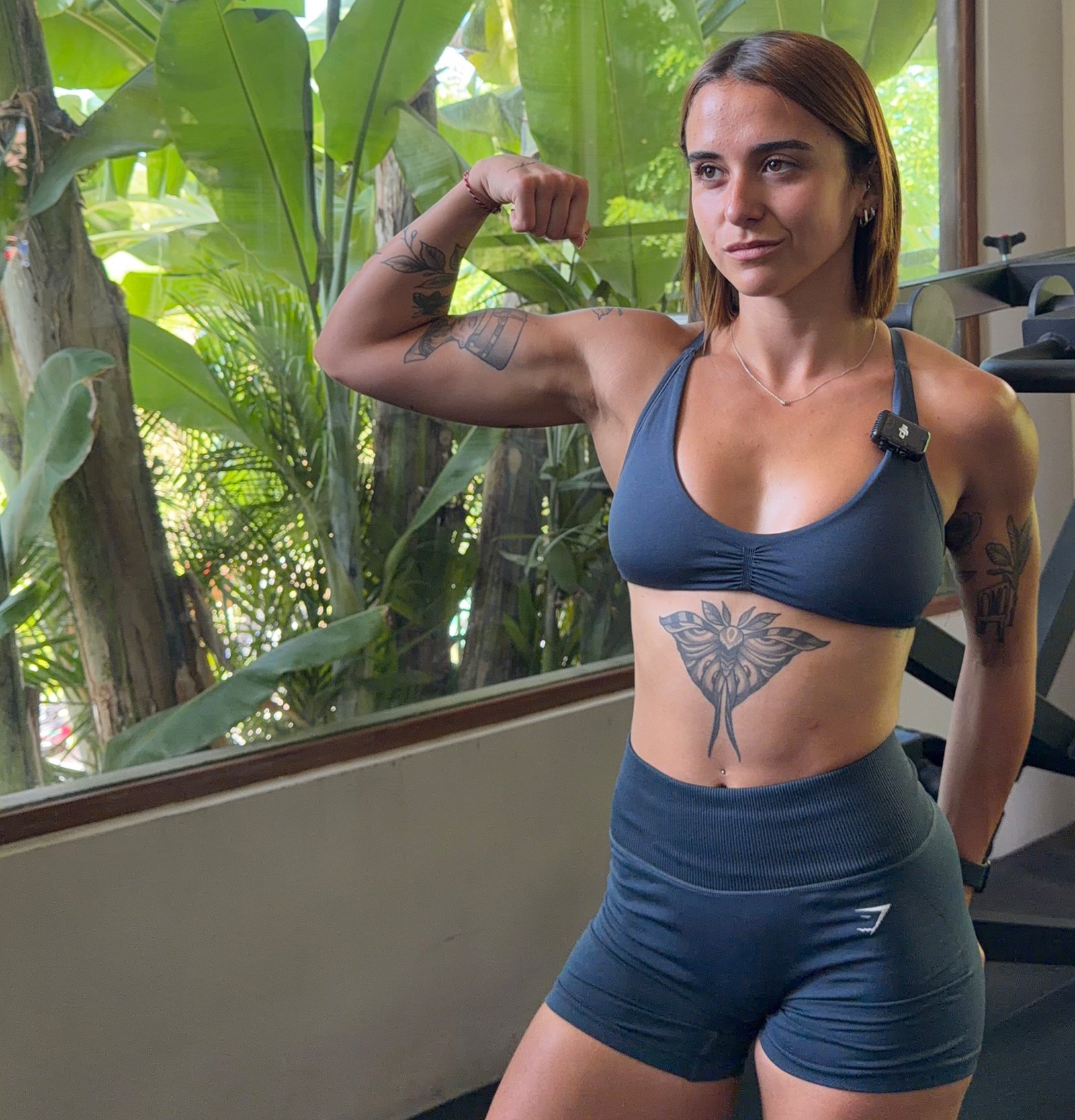 María flexionando el brazo en el gimnasio